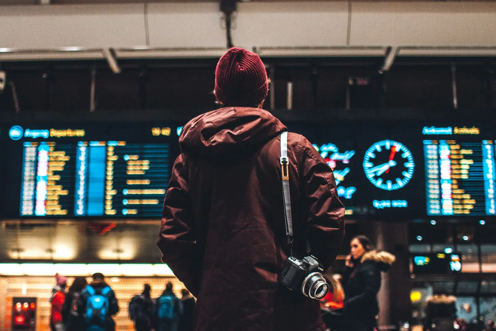 Reisender vor der Abflugtafel am Flughafen