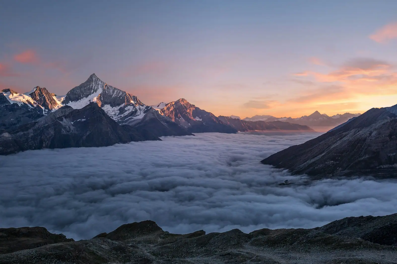 Berggipfel über dem Wolkenmeer bei Sonnenuntergang