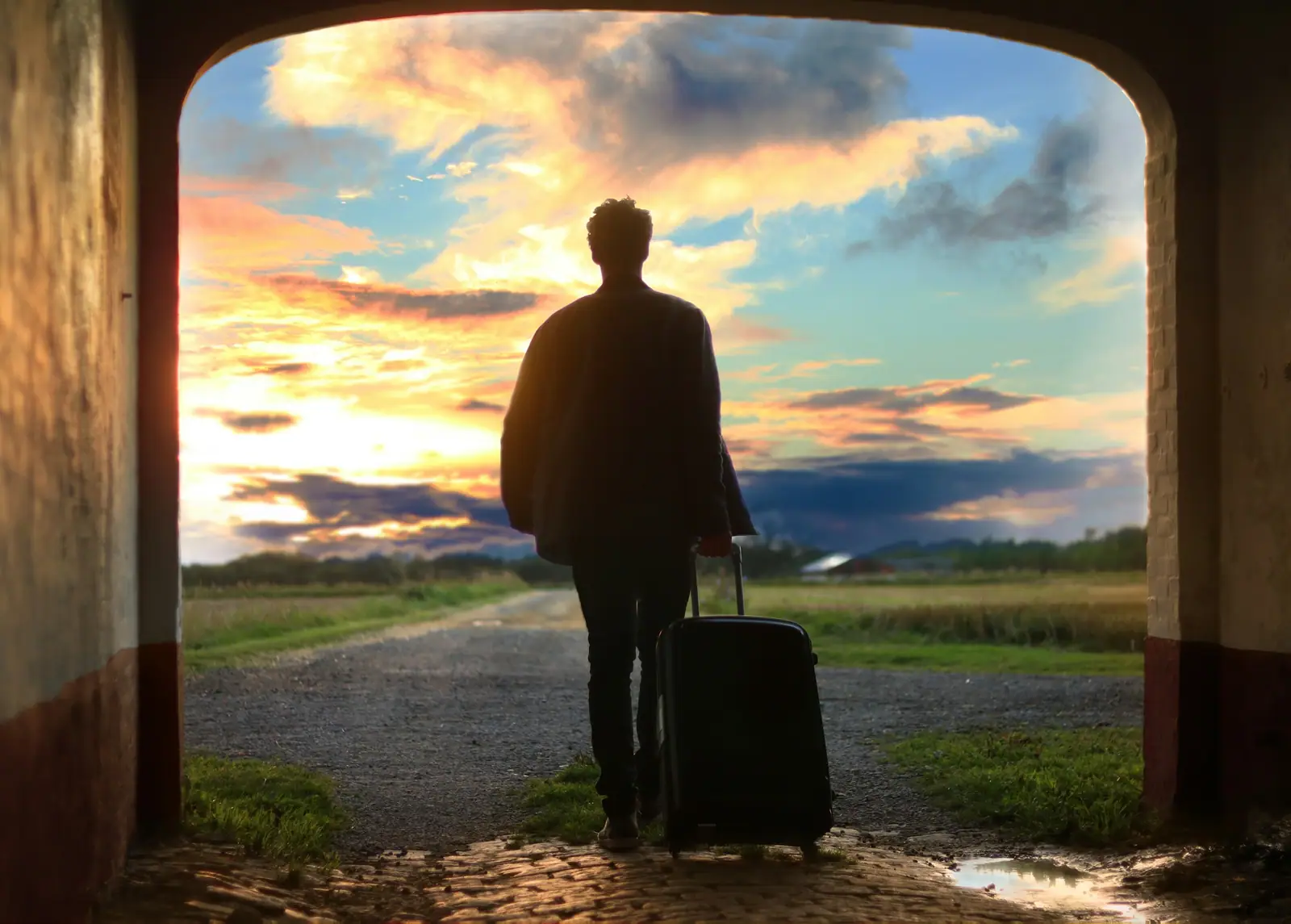 Reisender mit Koffer im Abendlicht am Flughafen